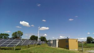 Impianto Fotovoltaico di S.Michele. Si possono notare qua i pannelli e le cabine (in questo caso separate) di comando con gli inverter e di trasformazione con il traformatore trifase.